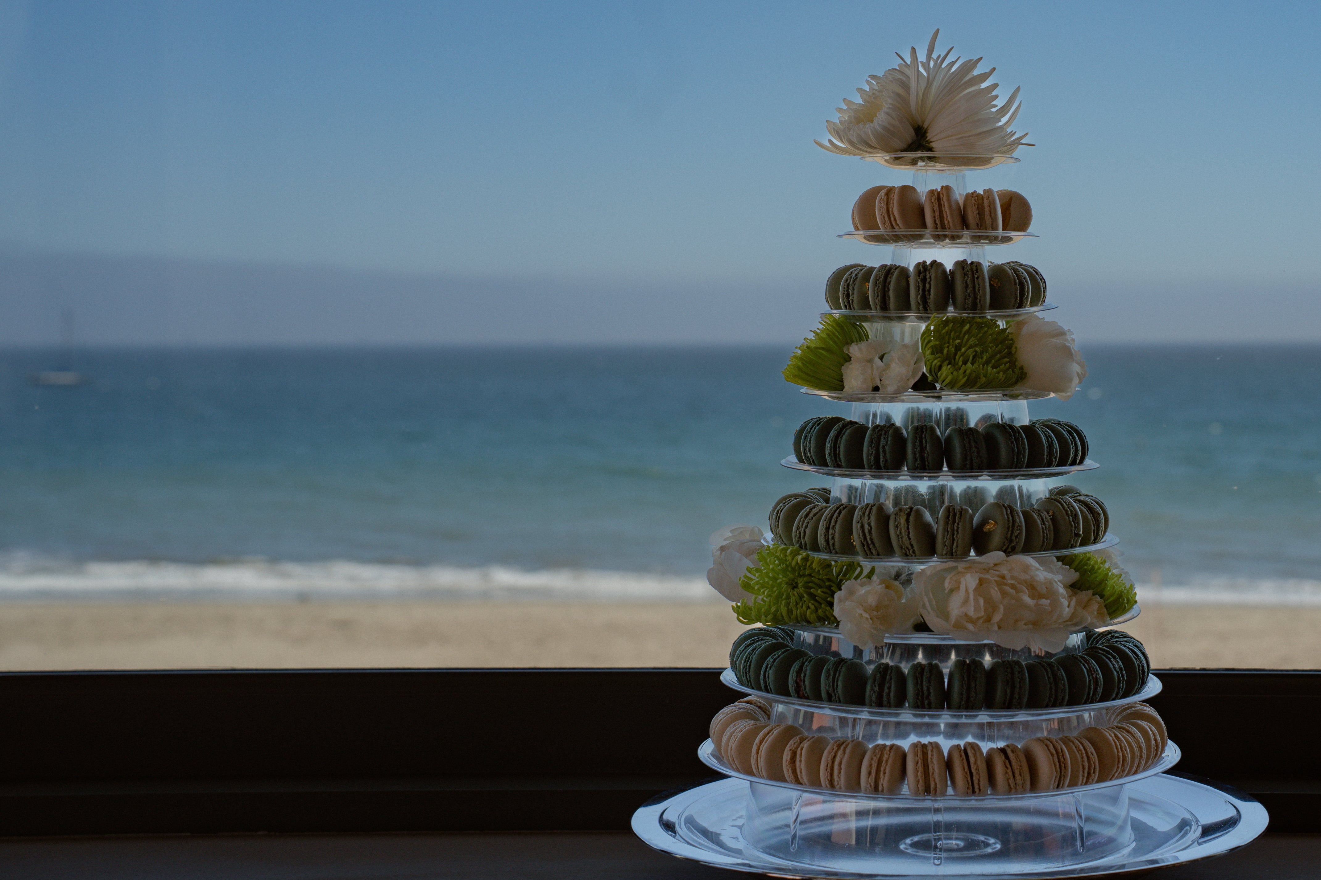 Decorative tower of macarons on a stand with ocean view